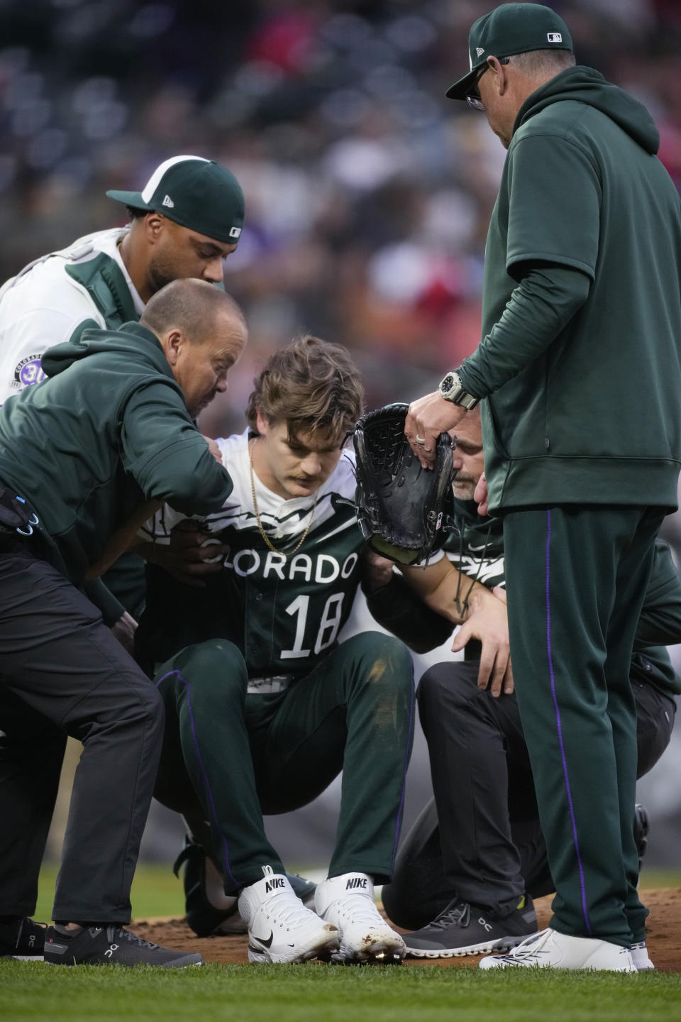 Trainers help up Colorado Rockies starting pitcher Ryan Feltner after he was struck by a batted ball during the second inning of the team's baseball game against the Philadelphia Phillies on Saturday, May 13, 2023, in Denver. (AP Photo/David Zalubowski)