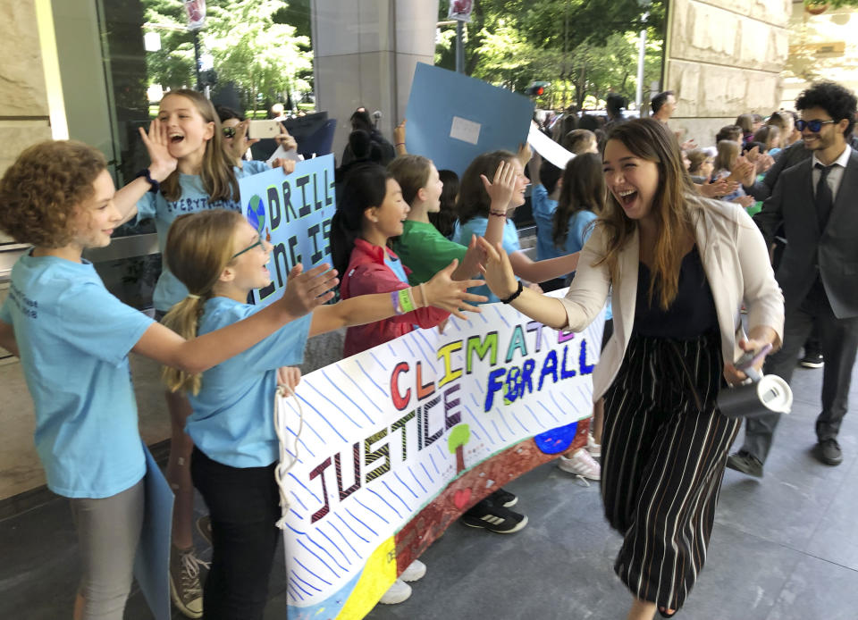 FILE - In this June 4, 2019, file photo Kelsey Juliana, of Eugene, Ore., a lead plaintiff who is part of a lawsuit by a group of young people who say U.S. energy policies are causing climate change and hurting their future, greets supporters outside a federal courthouse, in Portland, Ore. A federal appeals court on Friday, Jan. 17, 2020, has dismissed the lawsuit by 21 young people who claimed the U.S. government's climate policy harms them and jeopardizes their future. (AP Photo/Andrew Selsky, File)