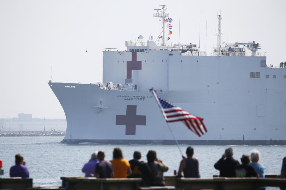 Local residents watch as the USNS Comfort departs Hampton Roads en route to New York to help in the response to the coronavirus outbreak Saturday, March 28, 2020, in Hampton, Va. (AP Photo/Steve Helber)