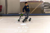 In this Nov. 17, 2019, photo provided by the University of Michigan, Bryan Kreps plays a game modeled after soccer and air hockey using the iGYM system at the university in Ann Arbor, Mich. A University of Michigan research team has created iGYM, an augmented reality system that allows people with different levels of mobility to play and exercise together. (Roger Hart/University of Michigan via AP)