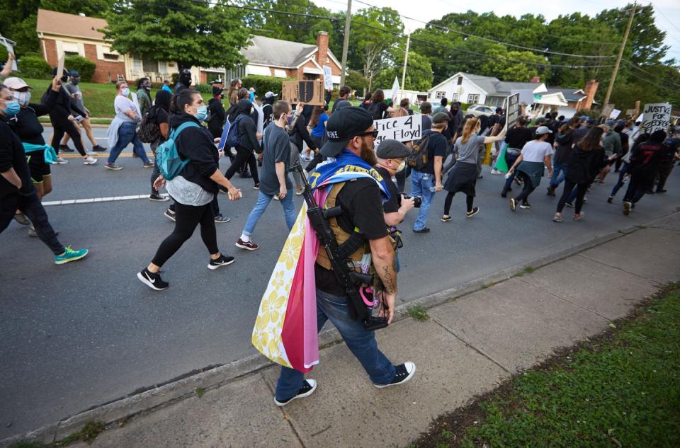 <span class="caption">A member of the far-right Boogaloo Bois group walks next to protestors in Charlotte, N.C., on May 29, 2020.</span> <span class="attribution"><a class="link " href="https://www.gettyimages.com/detail/news-photo/member-of-the-far-right-militia-boogaloo-bois-walks-next-to-news-photo/1216297279" rel="nofollow noopener" target="_blank" data-ylk="slk:Logan Cyrus/AFP via Getty Images;elm:context_link;itc:0;sec:content-canvas">Logan Cyrus/AFP via Getty Images</a></span>