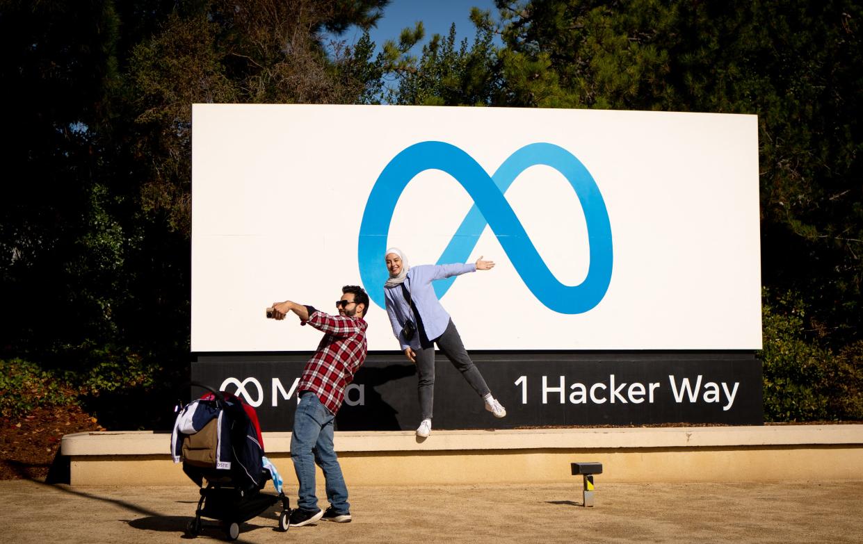 Anwar Almojarkesh (L) and Alan Chalabi (R) from England take a photo at Meta (formerly Facebook) corporate headquarters in Menlo Park, California on November 9, 2022. - Facebook owner Meta will lay off more than 11,000 of its staff in 