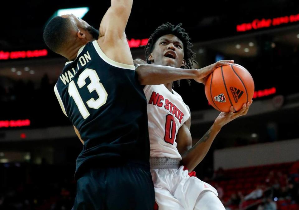 N.C. State’s Terquavion Smith (0) drives to the basket as Wake Forest’s Dallas Walton (13) defends during the first half of N.C. State’s game against Wake Forest at PNC Arena in Raleigh, N.C., Wednesday, Feb. 9, 2022.