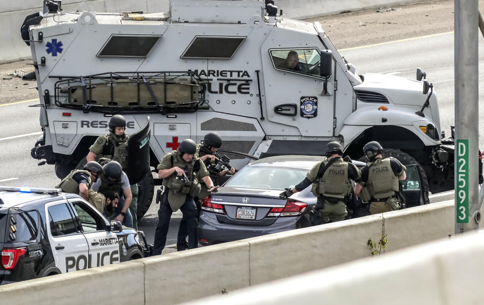 Marietta Police arrest a man after a standoff along the southbound lanes of Interstate 75, Friday, March 29, 2019, near Marietta, Ga., northwest of Atlanta. Marietta police said an armed driver had stopped on the freeway and wasn't cooperating with officers. Police had followed the vehicle to I-75 since it matched the description from an armed robbery nearby. (John Spink/Atlanta Journal-Constitution via AP)