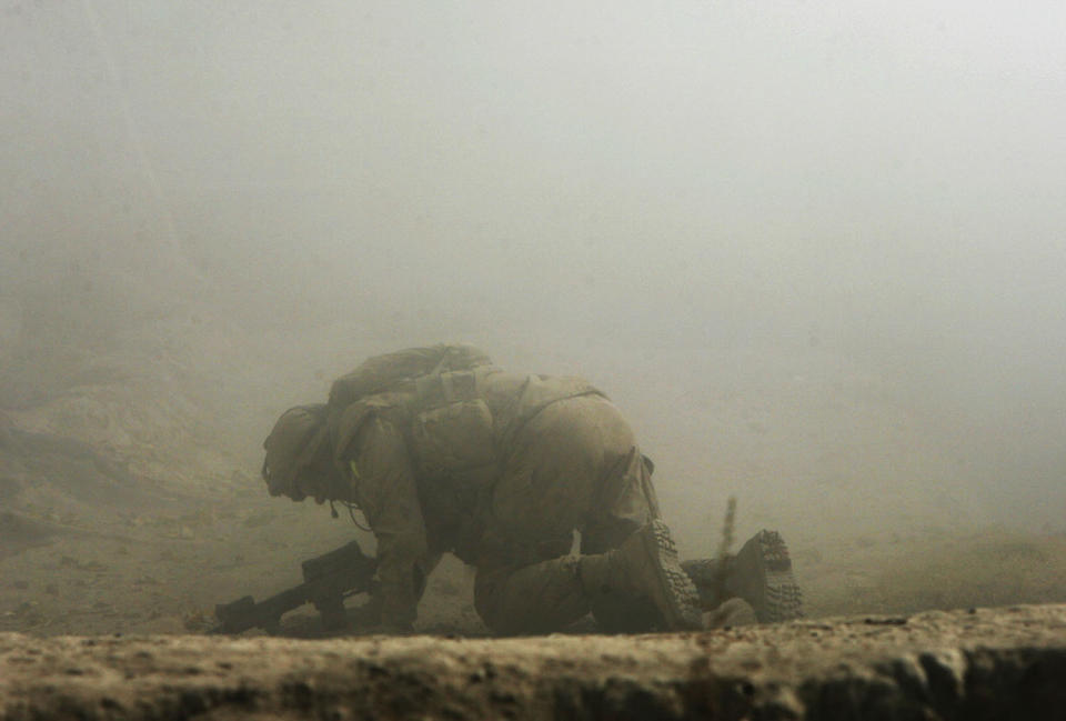 <p>A wounded Canadian soldier from the NATO-led coalition crawls for cover seconds after his position was hit by a Taliban shell fired from an 82-millimeter recoilless rifle during an ambush in Zhari district of Kandahar province, southern Afghanistan, Oct. 23, 2007. (Photo: Finbarr O’Reilly/Reuters) </p>
