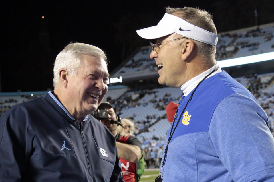 North Carolina head coach Mack Brown, left, and Pittsburgh head coach Pat Narduzzi, right, laugh as they chat before the start of an NCAA college football game in Chapel Hill, N.C., Saturday, Oct. 29, 2022. (AP Photo/Chris Seward)