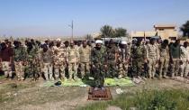 Shi'ite cleric Ahmed al-Rubaei (C) prays with Iraqi soldiers and Shiite fighters in Udhaim dam, north of Baghdad March 1, 2015. REUTERS/Thaier Al-Sudani