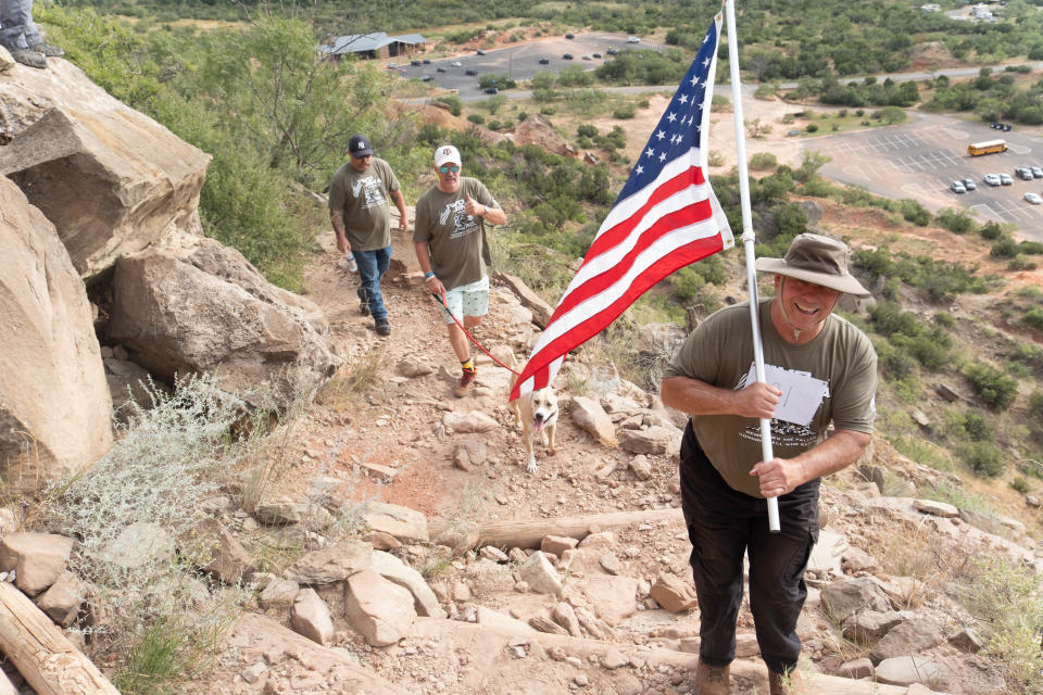 A seasoned team and their faithful companion make their way up the trail Saturday morning at the Iwo Jima Flag Run at Palo Duro Canyon.