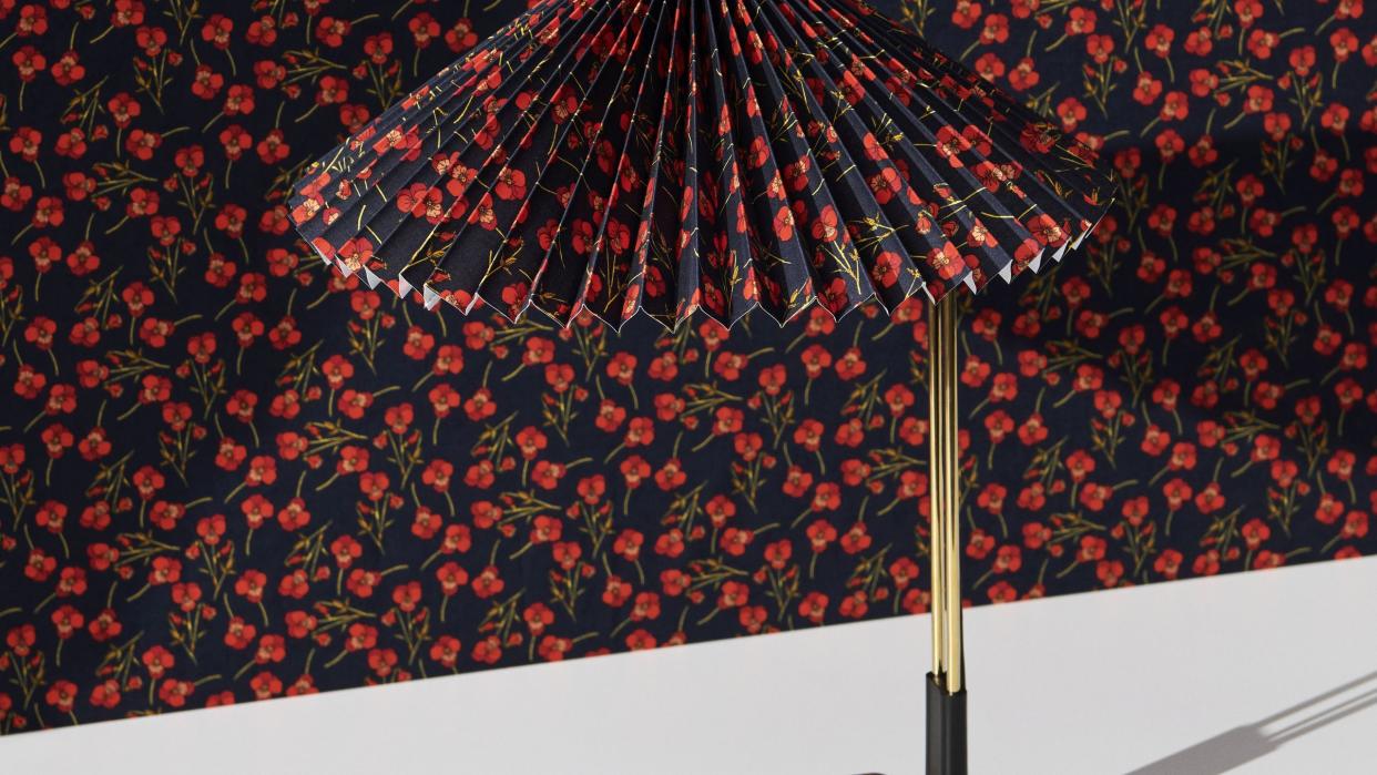 a table lamp with a black and red floral print lampshade