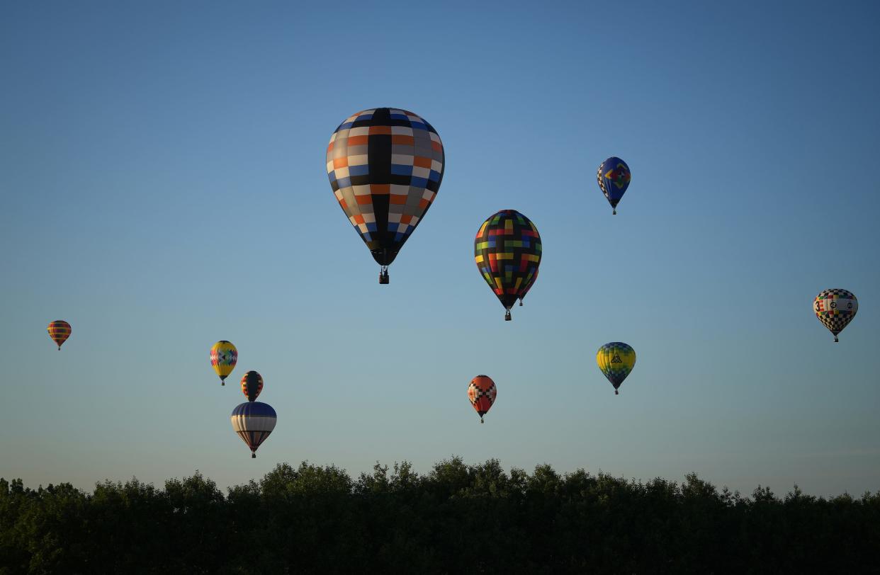 Hot air balloons fill the sky as they soar closer to the landing site during the National Balloon Classic in 2022.