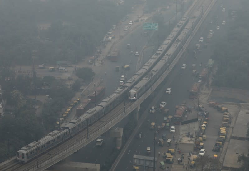 Metro trains move on a foggy morning in Noida on the outskirts of New Delhi