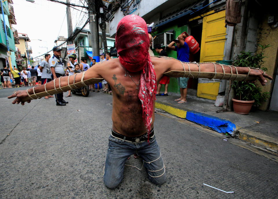 <p>Kurz vor dem Osterfest bittet ein Büßer in der philippinischen Stadt Mandaluyong mit vermummtem Gesicht und an Holzpflöcke gebundenen Armen um Vergebung. (Bild: REUTERS/Romeo Ranoco) </p>