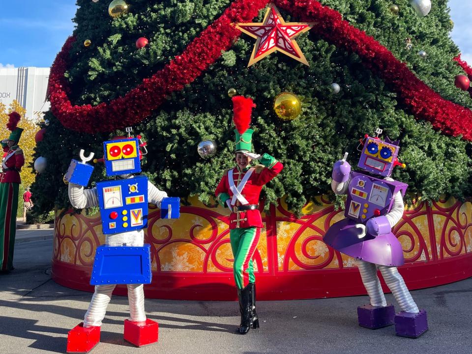 street performers in front of the christmas tree at universal orlando