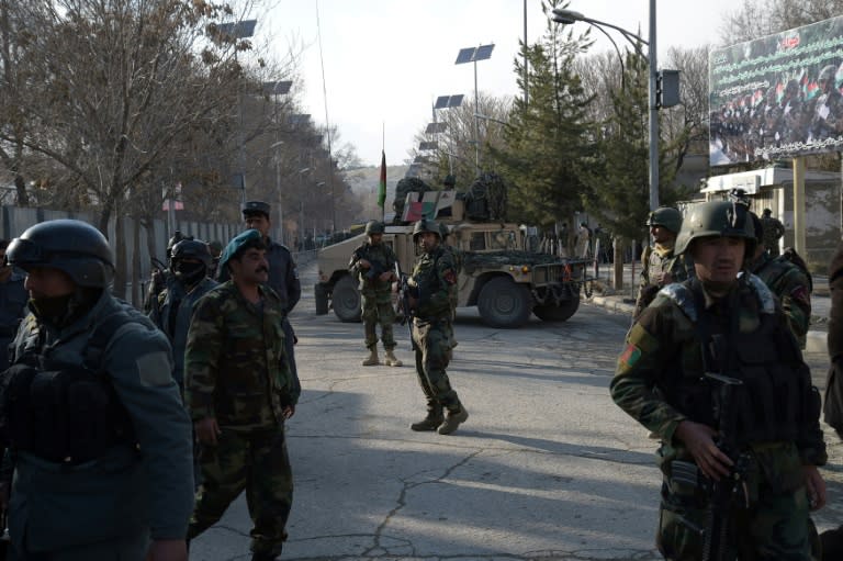 Afghan security personnel stand guard in front of the main gate of a military hospital in Kabul on March 8, 2017, after a deadly attack claimed by the Islamic State group