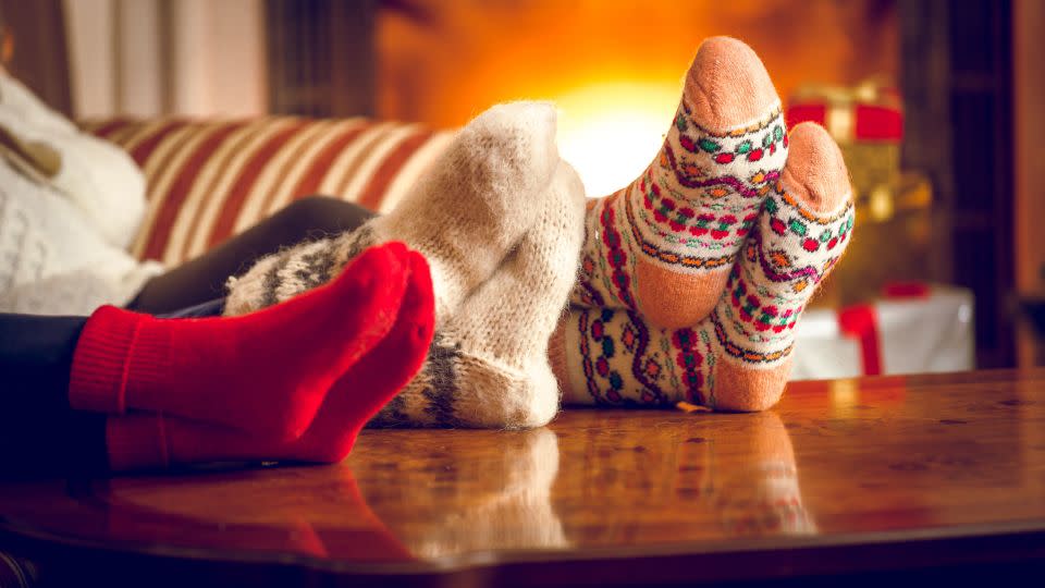 Cozying up underneath layers of clothing or blankets (or both) can help insulate you from the cold. - Shutterstock