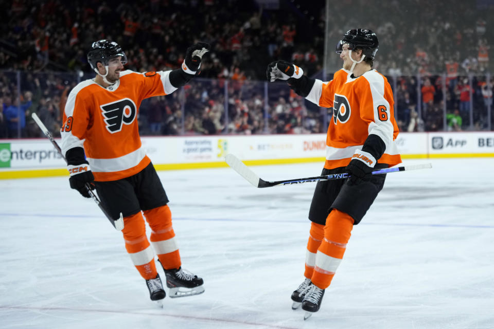 Philadelphia Flyers' Travis Sanheim, right, and Noah Cates celebrate after a goal by Sanheim during the second period of an NHL hockey game against the Vegas Golden Knights, Tuesday, March 14, 2023, in Philadelphia. (AP Photo/Matt Slocum)