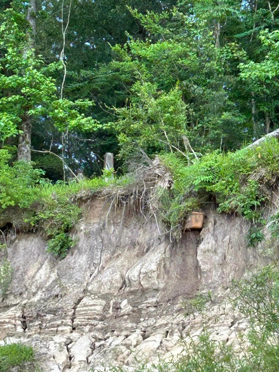 A coffin juts out of a riverbank in a cemetery high above the Pearl River in Mississippi in this photo by Judy Blair Berry.