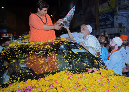 Pragya Thakur, a Bharatiya Janata Party (BJP) candidate in the parliamentary election, receives a bouquet from a Muslim man during her election campaign rally in Bhopal, India, April 30, 2019. Picture taken April 30, 2019. REUTERS/Raj Patidar