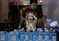 A street vender adjusts bottles of hand sanitizers amid the outbreak of the new coronavirus in Bangkok, Thailand, Thursday, April 2, 2020. The new coronavirus causes mild or moderate symptoms for most people, but for some, especially older adults and people with existing health problems, it can cause more severe illness or death. (AP Photo/Gemunu Amarasinghe)