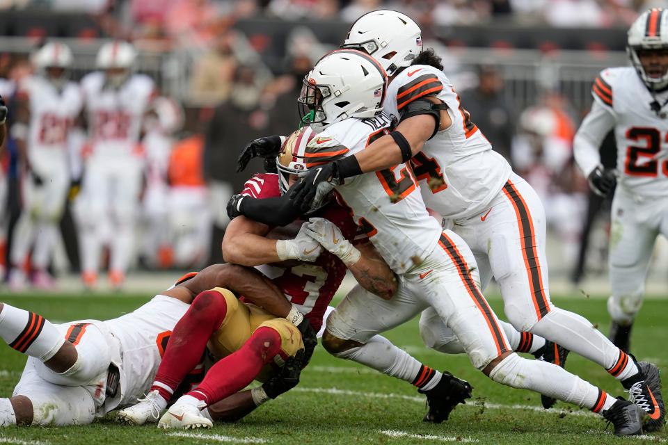 San Francisco 49ers running back Christian McCaffrey, middle left, is tackled by Cleveland Browns defensive end Myles Garrett, left, safety Grant Delpit, middle right, and linebacker Sione Takitaki during the second half of an NFL football game Sunday, Oct. 15, 2023, in Cleveland. (AP Photo/Sue Ogrocki)