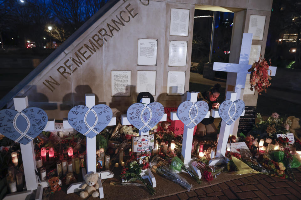 Amy Mack lights candles at a memorial at Veteran's Park for the victims of Sunday's deadly Christmas parade crash in Waukesha, Wis., Tuesday, Nov. 23, 2021. On Sunday an SUV plowed into a Christmas parade in suburban Milwaukee, killing multiple people and injuring scores more. (AP Photo/Jeffrey Phelps)