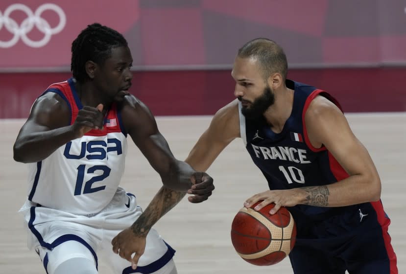 France's Evan Fournier (10) drives around United States' Jrue Holiday.