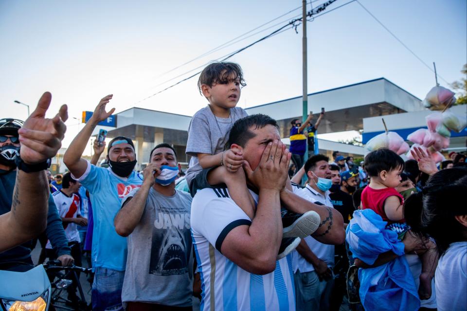 Fans cheer and shout to pay tribute during the burial ceremony of Argentine football legend Diego Maradona (Getty Images)