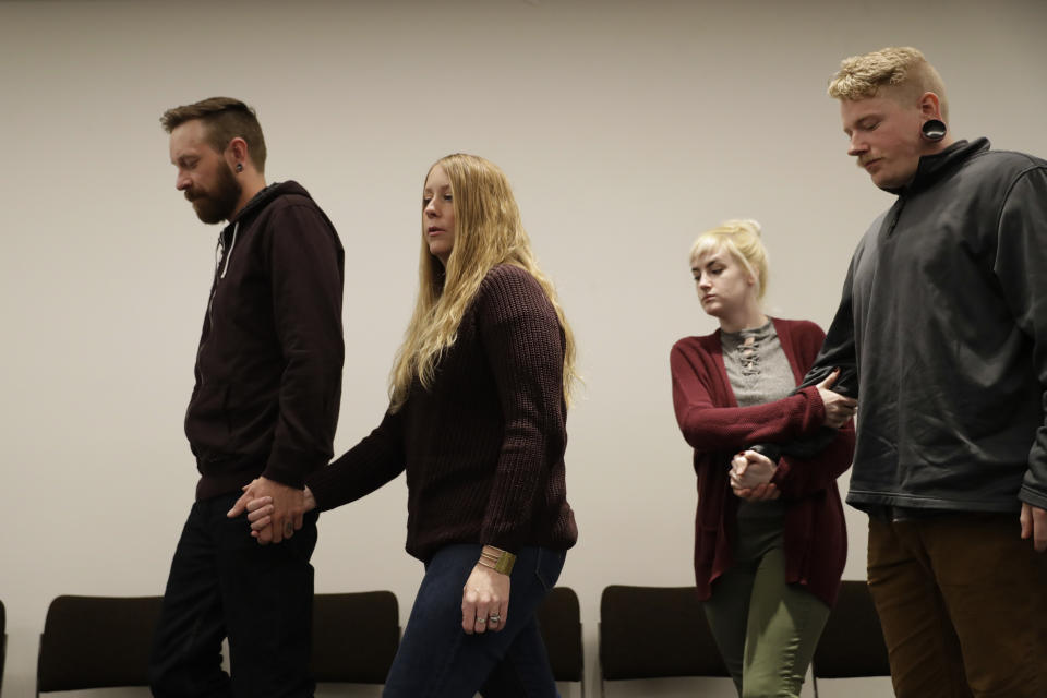 Dallas Cochran, right, the son of Kurt Cochran who was killed in Wednesday's London attack, walks away at the end of a family press conference with his partner Cheyenne Peck, second right, and the brother of Kurt's wife Melissa, who was injured in the attack, Michael Payne, left, with his wife Shantell Payne, second left, at New Scotland Yard, the headquarters of the Metropolitan Police force, in London, Monday, March 27, 2017. (AP Photo/Matt Dunham)