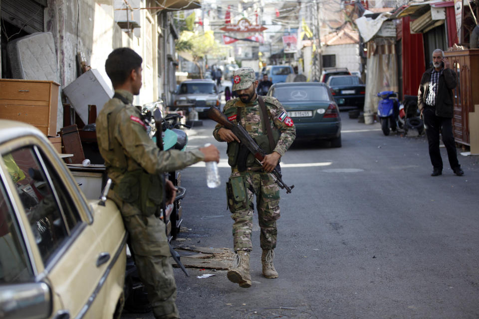 Members of the Democratic Front for Liberation of Palestine stand guard in the Burj Shamali Palestinian refugee camp, in the southern port city of Tyre, Lebanon, Saturday, Dec. 11, 2021. Arms stored for the Palestinian Hamas group exploded in a refugee camp in southern Lebanon on Friday night, killing and wounding a number of people, the state-run National News Agency reported. (AP Photo/Mohammed Zaatari)