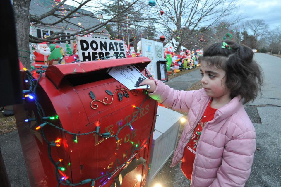 Samantha Lindberg, 5, of Hanson, places a letter to Santa in a special mailbox set up in front of the Holiday House of Hanson.