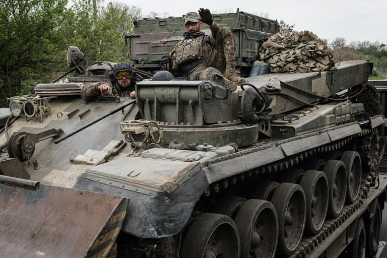 Des soldats ukrainiens à bord d'un char transporté sur un camion, près de Kramatorsk, dans l'est de l'Ukraine, le 30 avril 2022 (AFP/Yasuyoshi CHIBA)