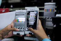 A worker conducts a color test on OPPO F1s smartphones at an OPPO smartphone factory in Tangerang, Indonesia, September 20, 2016. REUTERS/Beawiharta