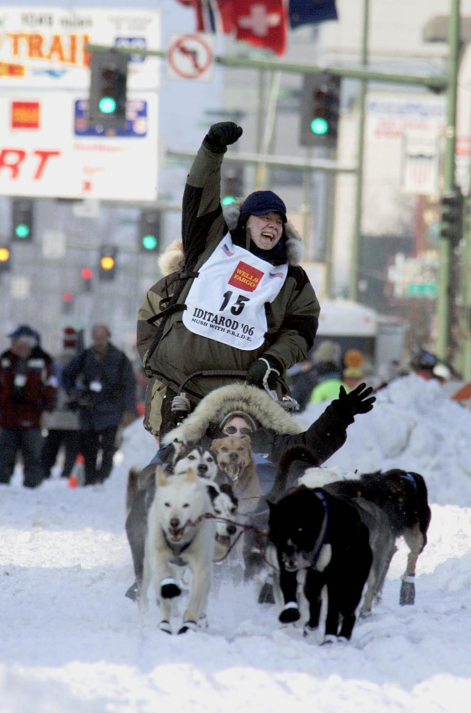 Author Gary Paulsen, from Tularosa, N.M., cheers he drives his dog team down Fourth Avenue with Carole Markell, from Temple City, Calf., in the sled, during the ceremonial start of the Iditarod Trail Sled Dog Race Saturday, March 4, 2006, in Anchorage, Alaska. Among the many books Paulsen wrote are "Winterdance: The Fine Madness of Running the Iditarod" and "My Life in Dog Years."