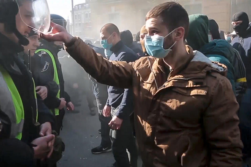 In this image from video provided Radio Free Europe/Radio Liberty, far-right demonstrators clash with riot police outside the presidential administration building in Kiev, Ukraine, Saturday, March 9, 2012. Three police officers in Ukraine have been injured in a clash with far-right demonstrators in the capital. The violence occurred outside the presidential administration building in Kiev where several hundred demonstrators had gathered Saturday to call for arrests of top figures in an alleged military corruption scandal. (Radio Free Europe/Radio Liberty via AP)