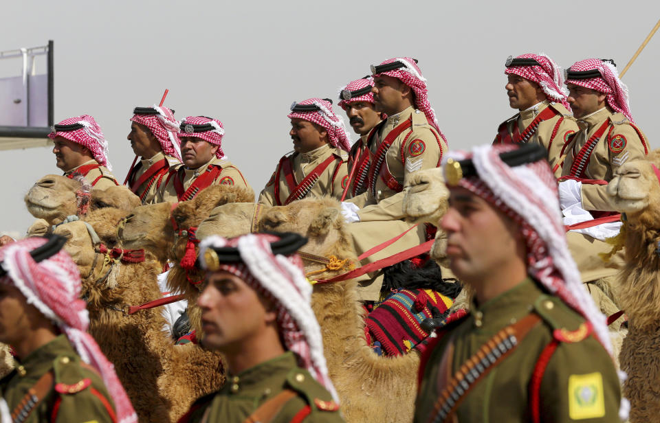 An honor guard on camel back greets Saudi Arabia's King Salman, not seen, in a lavish welcome ceremony complete with cannon salutes, Amman Jordan, Monday, March 27, 2017. Salman is in Jordan to attend the annual Arab Summit, to be held on Wednesday. Issues on the summit agenda include conflicts in Syria, Libya and Yemen. Saudi Arabia is an important financial backer of Jordan. (AP Photo/ Raad Adayleh)