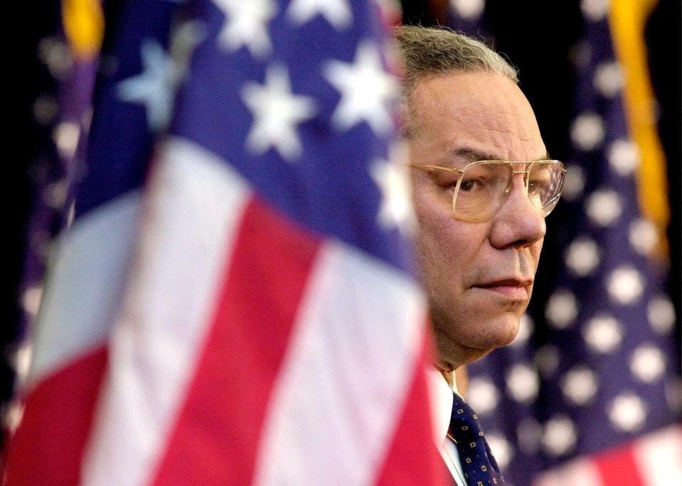 Then-Secretary of State Colin Powell looks on as President Bush addresses State Department employees at the State Department in Washington on Feb. 15, 2001. Powell, former Joint Chiefs chairman and secretary of state, has died from COVID-19 complications, his family said Monday.