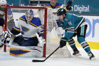 St. Louis Blues goaltender Jordan Binnington (50) blocks a shot by San Jose Sharks center Ryan Donato (16) during the first period of an NHL hockey game in San Jose, Calif., Saturday, Feb, 27, 2021. (AP Photo/Tony Avelar)