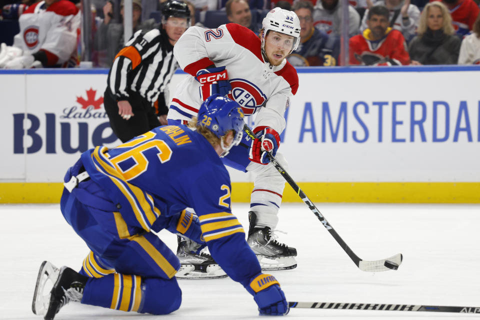 Montreal Canadiens center Rem Pitlick (32) passes the puck past Buffalo Sabres defenseman Rasmus Dahlin (26) during the second period of an NHL hockey game, Thursday, Oct. 27, 2022, in Buffalo, N.Y. (AP Photo/Jeffrey T. Barnes)