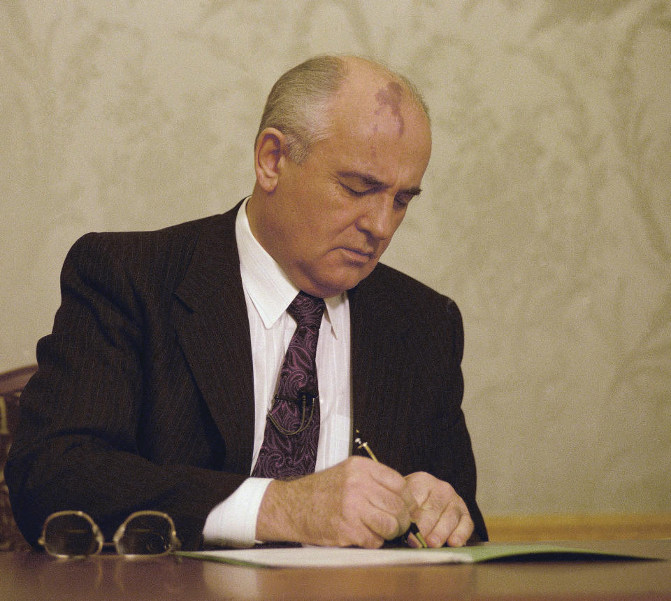 FILE - Mikhail Gorbachev, the final leader of the Soviet Union, signs the decree relinquishing control of nuclear weapons to Boris Yeltsin at the Kremlin in Moscow, Dec. 25, 1991. It was a momentous event that ended an era 30 years ago - Soviet President Mikhail Gorbachev's resignation drawing a line under the USSR's existence. The AP Moscow photo chief, Liu Heung Shing, was the only foreign photographer who captured the final moments of the Soviet Union on Dec. 25, 1991. (AP Photo/Liu Heung Shing, File)