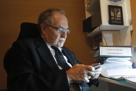 Attorney and law professor Alan Dershowitz checks his telephone after discussing allegations of sex with an underage girl levelled against him, during an interview at his home in Miami Beach January 5, 2015. REUTERS/Andrew Innerarity