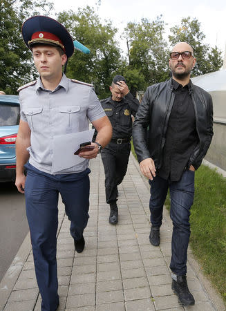 FILE PHOTO - Russian theatre director Kirill Serebrennikov (R), who was accused of embezzling state funds and placed under house arrest, is escorted after a court hearing in Moscow, Russia September 4, 2017. REUTERS/Maxim Shemetov