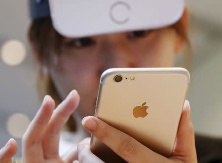 Japanese Makiko Maeda, 28, uses her iPhone 6s after purchasing it at the Apple Store at Tokyo's Omotesando shopping district September 25, 2015. REUTERS/Issei Kato