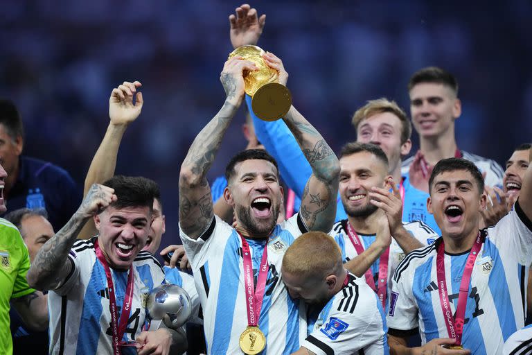 Nicolás Otamendi sostiene la Copa tras la consagración de la selección argentina como campeón del Mundial de Qatar 2022; a su derecha, Enzo Fernández, su compañero en Benfica.