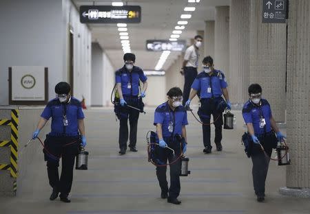 Employees from a disinfection service company sanitize the floor of Gimpo International Airport in Seoul, South Korea, June 17, 2015. REUTERS/Kim Hong-Ji