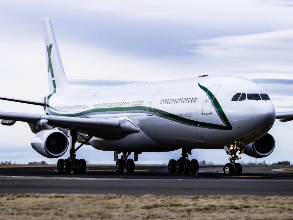 AirX Charters' A340 aircraft with a white fuselage and green stripe.