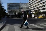 A pedestrian wearing a protective face mask walks on a zebra crossing, amid the spread of the coronavirus disease (COVID-19), in Athens