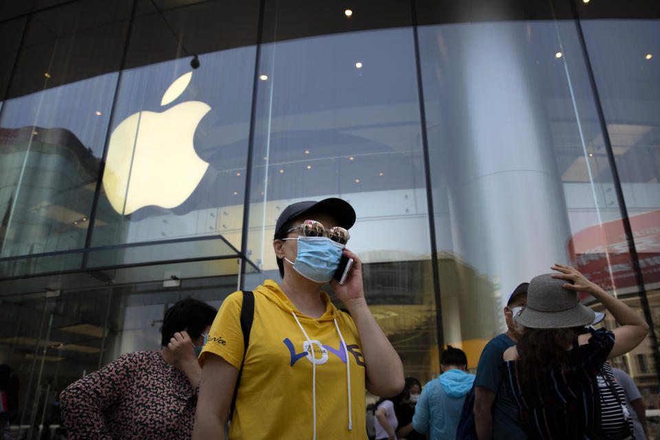 People wearing face masks to protect against the new coronavirus stand outside of an Apple store in Beijing, Saturday, June 6, 2020. China's capital is lowering its emergency response level to the second-lowest starting Saturday for the coronavirus pandemic. That will lift most restrictions on people traveling to Beijing from Wuhan and surrounding Hubei province, where the virus first appeared late last year. (AP Photo/Mark Schiefelbein)