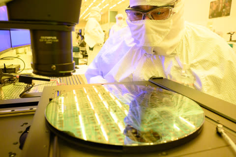 An Intel manufacturing technician at Fab 11X in Rio Rancho, New Mexico, inspects a 300-millimeter silicon wafer in January 2024. (Credit: Intel Corporation)