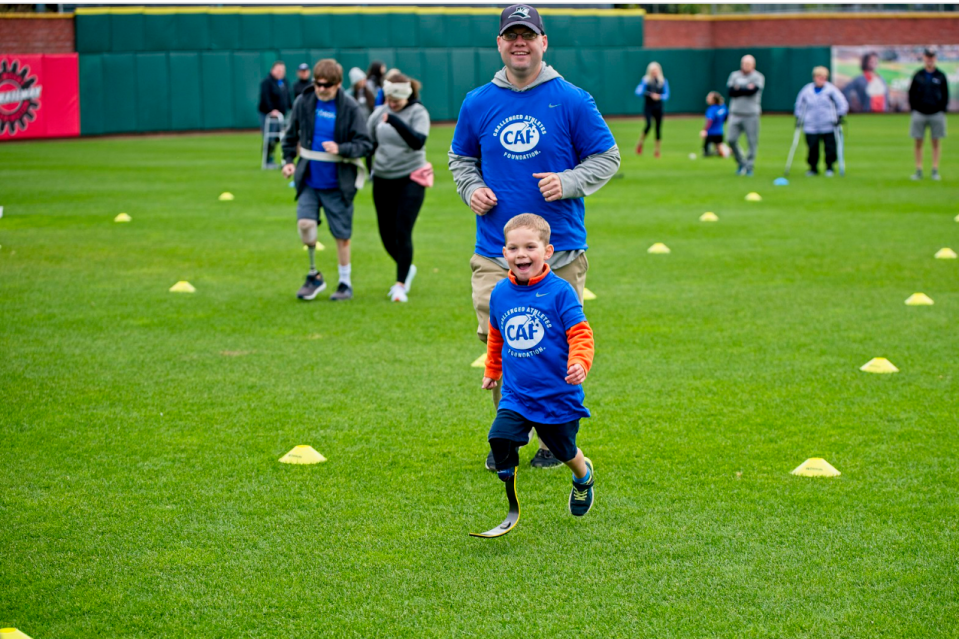 On Oct. 2 at Delta Dental Stadium in Manchester, 3-year-old TJ DeAngelo received a new Nike running blade prosthesis. His dad, John DeAngelo, runs behind him.