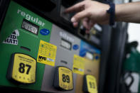 Wallace Reid purchases fuel for the vehicle he drives to make a living using ride-share apps, Wednesday, June 22, 2022, in the Queens borough of New York. Millions of Americans who rely on their cars for work are changing their habits, signing up for carpools or even ditching their cars for bicycles as gas prices recently hit $5 per gallon for the first time ever. (AP Photo/John Minchillo)